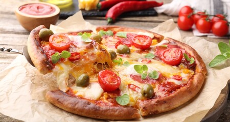 Taking piece of delicious pizza with cheese, tomatoes and olives at table, closeup