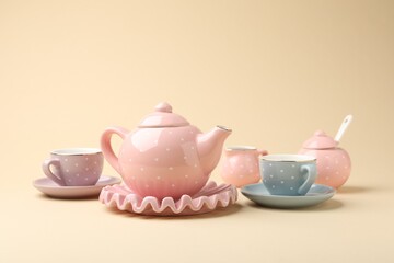 Beautiful ceramic tea set for children on beige background