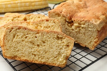 Freshly baked cut cornbread on white table, closeup