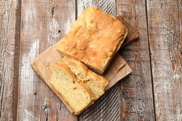 Freshly baked cut cornbread on wooden table, top view