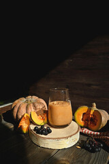 Pumpkin smoothie is a healthy drink. It is healthy and nutritious food for autumn. A vitamin drink made from pumpkin and other vegetables on a rustic background.