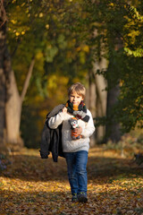 Amazing blond boy, cute child, enjoying a sunny day in Botanical garden in Prague during the halloween exhibition of pumpkins
