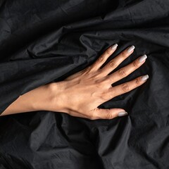 Close-up of a hand draped in black fabric