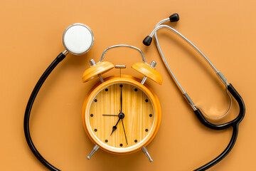 Stethoscope and vintage alarm clock, top view. Time for medical checkup