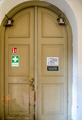 alte Doppeltüre zur Aussegnungshalle mit Hinweisschildern auf dem Ostfriedhof München