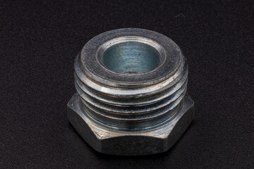 Close-up of a shiny metal bolt with external threads, representing engineering and industry