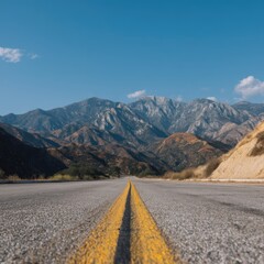 Naklejka premium Scenic mountain road vanishing point under clear blue sky day journey