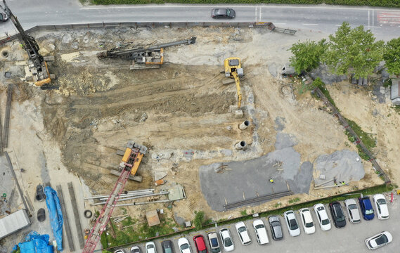 Aerial view of construction site with heavy machinery contrasting with the rows of parked cars, Avc&Auml;&plusmn;lar, &Auml;&deg;stanbul, T&Atilde;&frac14;rkiye.