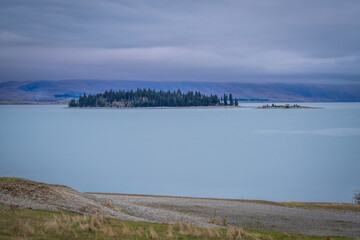 people enjoy beautiful landscape view of colorful leaves , turquoise lake and  snow cap moutain background at Lake Tekapo South Island New Zealand in the autumn