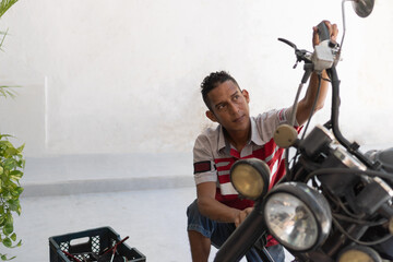Mechanic man repairing motorcycle engine during maintenance work