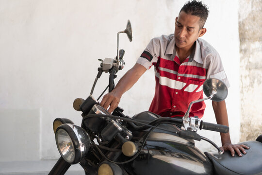 Mechanic man working on motorcycle maintenance and repair - Powered by Adobe