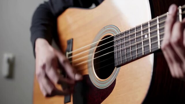 Close-up of skilled hands playing an acoustic guitar