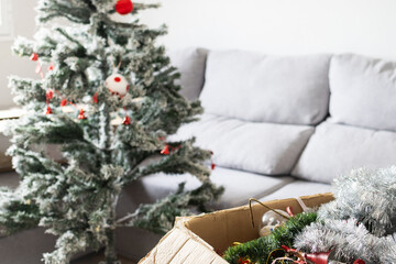 open box with Christmas decorations and Christmas tree in the background