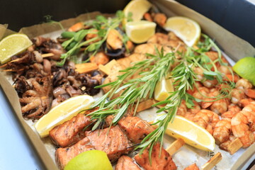 A colorful seafood platter features grilled shrimp and salmon, garnished with lime slices and fresh herbs. The dish is perfect for a casual gathering or summer barbecue.