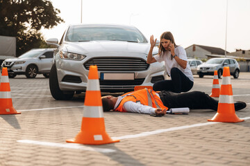 Calling the ambulance. Horrible crash, woman hit a man that is lying down on the road © standret
