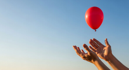 A red balloon floating freely into the blue sky as hands let go, symbolizing freedom, hope, release, and new beginnings. Perfect for concepts of letting go and positive emotions.