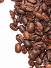 Roasted coffee beans scattered on white background close up