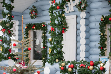 A festive decorated house with Christmas decorations and herbs among the fall of snow in a cozy winter setting