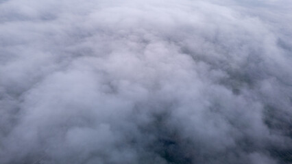 Aerial of Village in rain cloud cover tropical green mountain. Rainy season. Misty cover green forest. beautiful green village