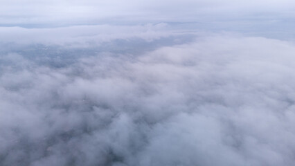 Aerial of Village in rain cloud cover tropical green mountain. Rainy season. Misty cover green forest. beautiful green village