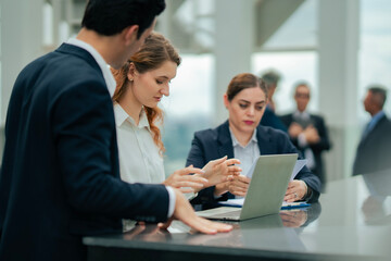 Corporate team engaged in outdoor business meeting, planning strategies on laptop, ideal for teamwork, leadership, and growth concepts at rooftop hotel.