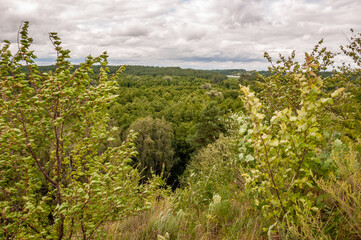 Obraz premium Mountainous landscape with cloudy sky. Scenic green hill mountain. Breathtaking summer day in wild mountain with forest and green valley. Mountain landscape with valley. Nature escape