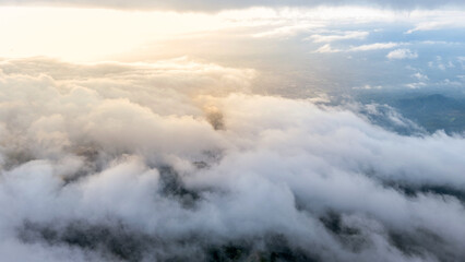 Aerial of Village in rain cloud cover tropical green mountain. Rainy season. Misty cover green forest. beautiful green village