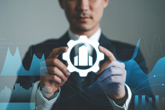 Business man holding gear with building icon for development and strategy innovation management success