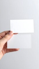 Two blank business cards held by a hand