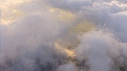 Obraz premium Aerial of Village in rain cloud cover tropical green mountain. Rainy season. Misty cover green forest. beautiful green village