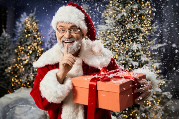 Delightful Santa Claus with a gift in a snowy winter wonderland