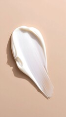 Creamy white cosmetic product smudge on a light beige background