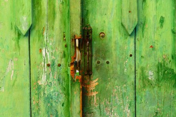 Green wooden rustic door with rusty lock for the key vintage background