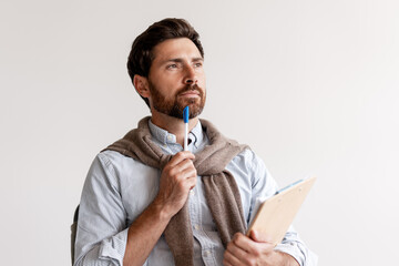 Thoughtful professional man holding clipboard contemplating new ideas