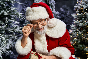 Joyful Santa enjoying a winter wonderland surrounded by fir trees and Christmas cheer