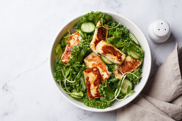 Cucumbers, sprouts and green leaves salad with fried halloumi.