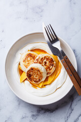 Homemade cottage cheese pancakes with yogurt and mango.