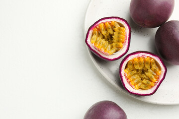 Fresh passion fruits on white table, space for text