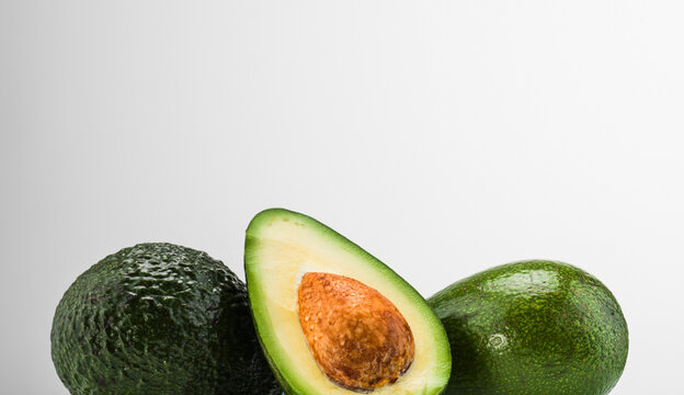 Still life of avocados, one halved.