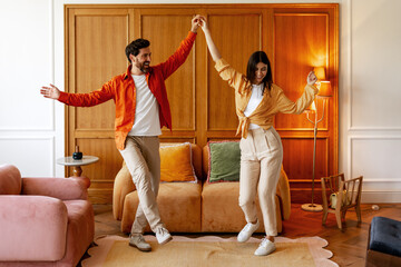Young couple dancing happily in living room