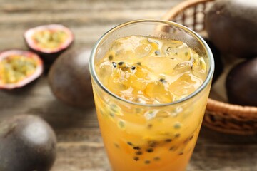 Tasty passion fruit drink and fresh fruits on wooden table, closeup