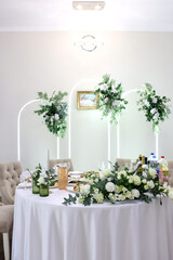 Wedding table with white tablecloth, floral arrangements and drinks prepared for guests.