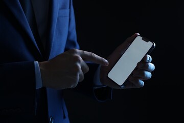Man with modern smartphone on black background, closeup. Mockup for design