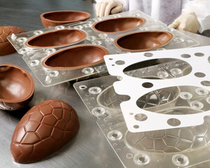 Large chocolate easter eggs being taken out of a form in the factory.