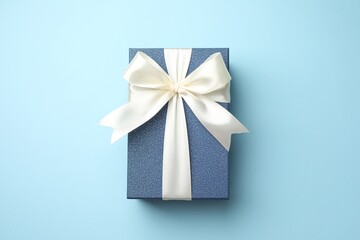 Gift box with beautiful bow on light blue background, top view