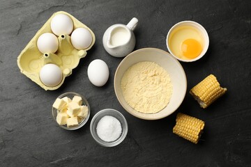 Cornbread preparation. Different ingredients on black textured table, flat lay