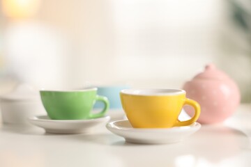 Tea set on white table indoors, closeup with space for text. Child's toy