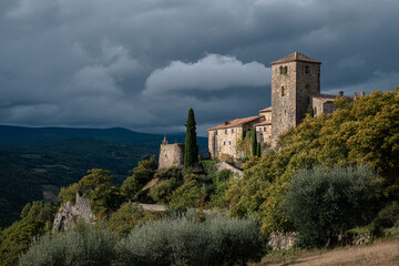 Fototapeta premium Old stone castle on a hill, dramatic clouds in the sky, side view, historical landmark