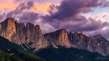 Expansive rugged mountain peaks under dramatic sunrise or sunset sky,