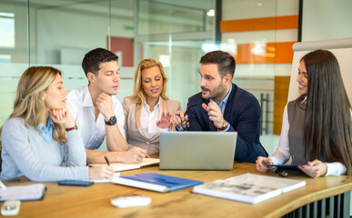 Dedicated business people working on detailed business plan for company development and growth during meeting